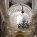 Dal soffitto dai toni celeste e oro scende un grande lampadario di cristallo